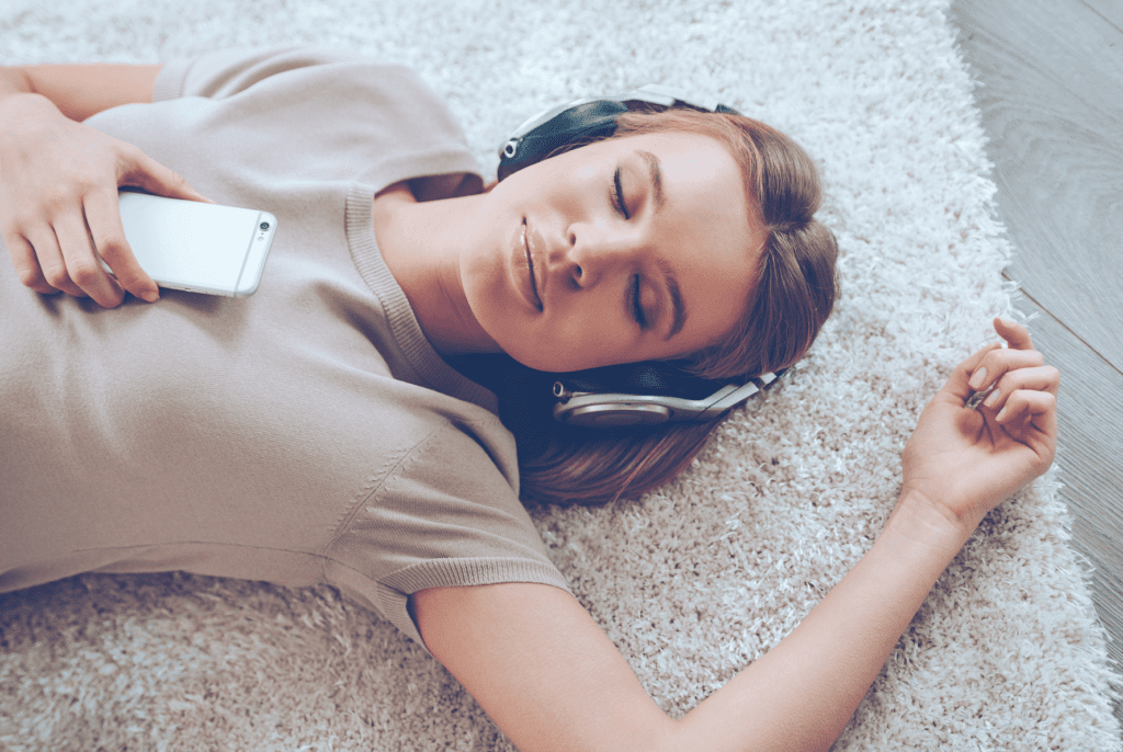 girl listening to hypnosis audio laying on the floor
