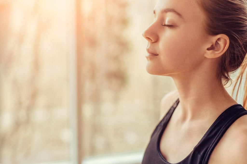 brunette woman peacefully practicing breathwork