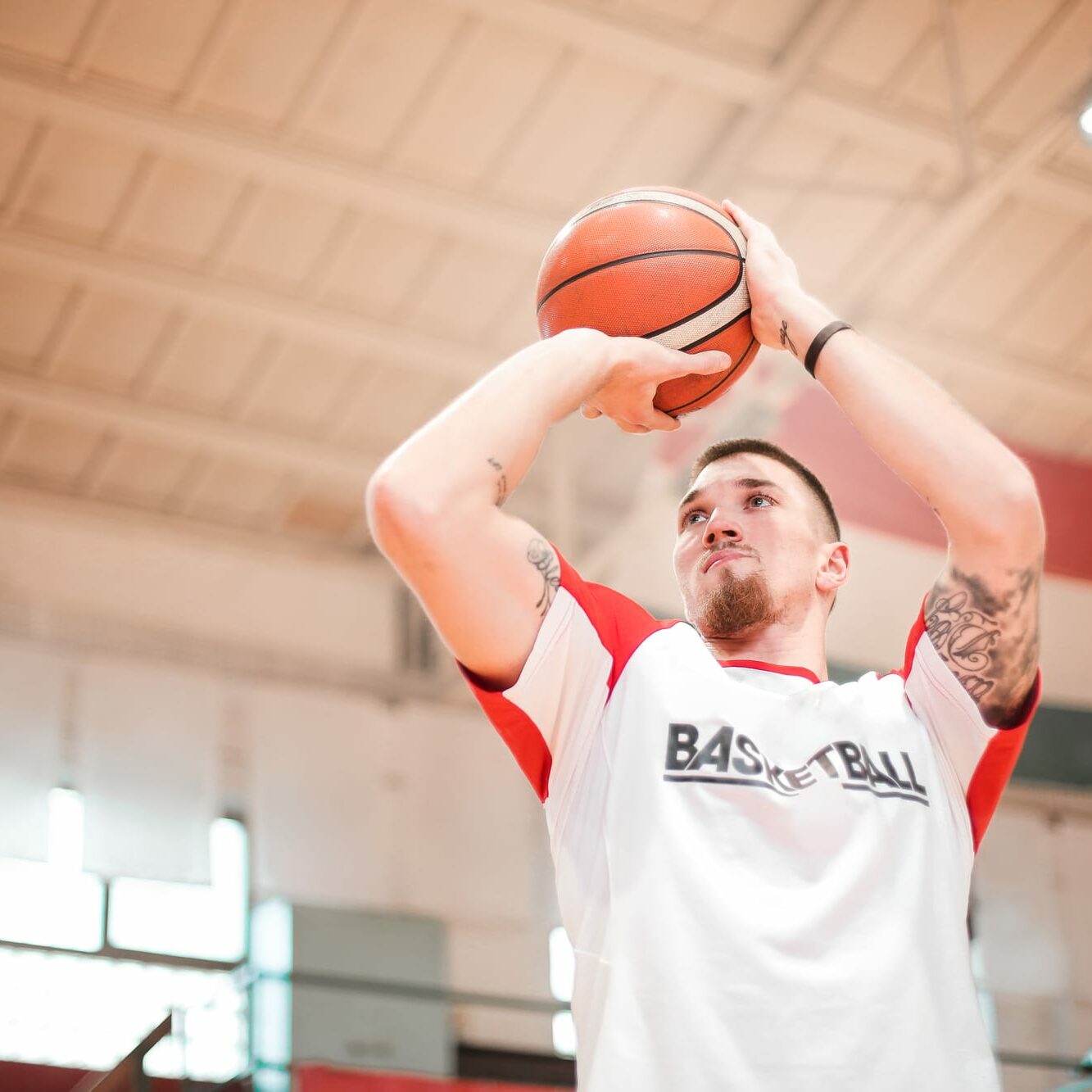 Man in white shirt shooting a basketball