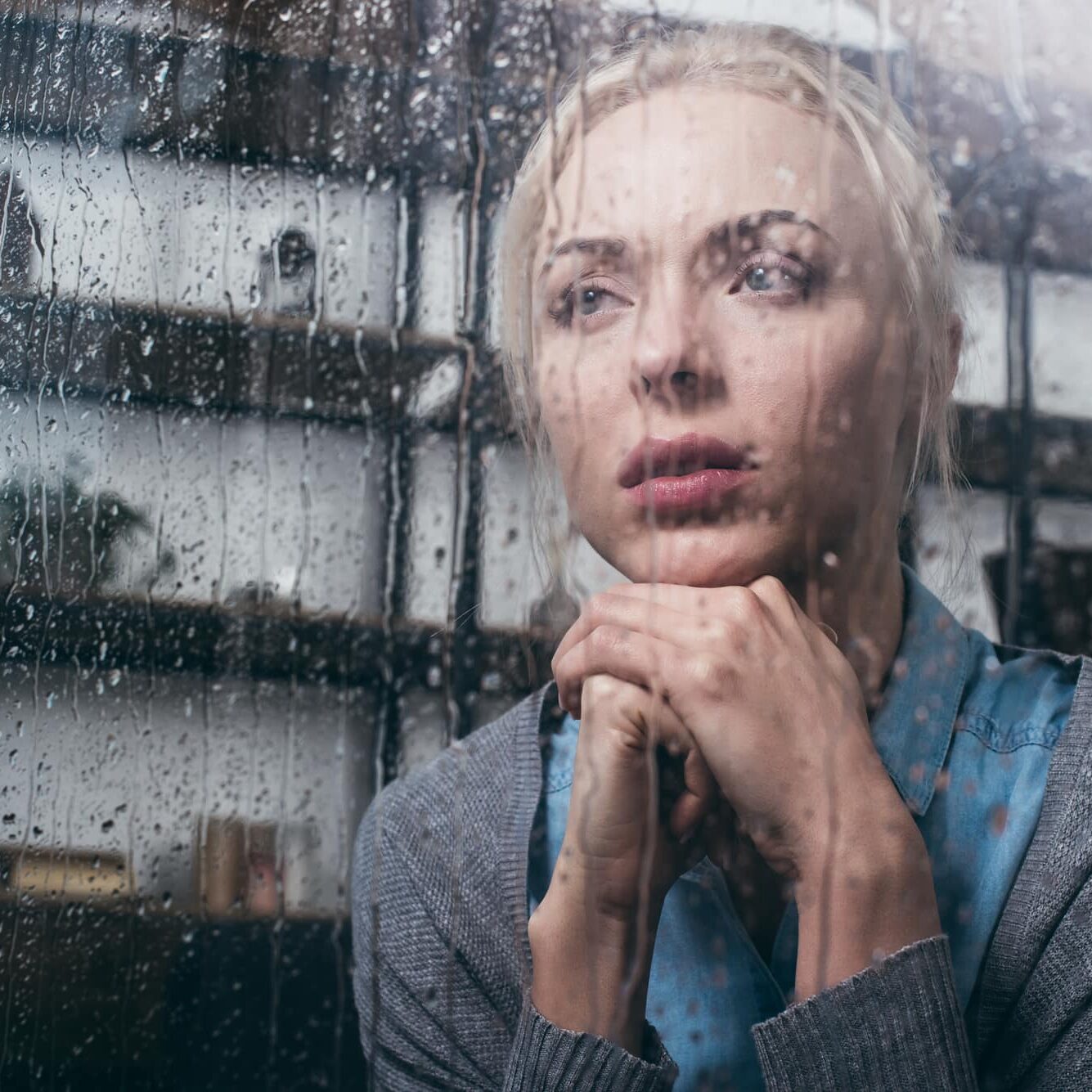 Women looking out rainy window